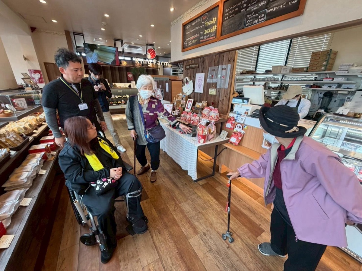 旅先のお店で、利用者さんとスタッフが買い物を楽しむ様子